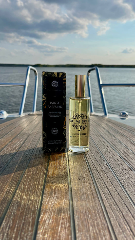 Eau de Parfum Signature Femme 100ml Flacon rechts, box links. Stehend auf einem Boot. Im Hintergrund die Reeling und der See