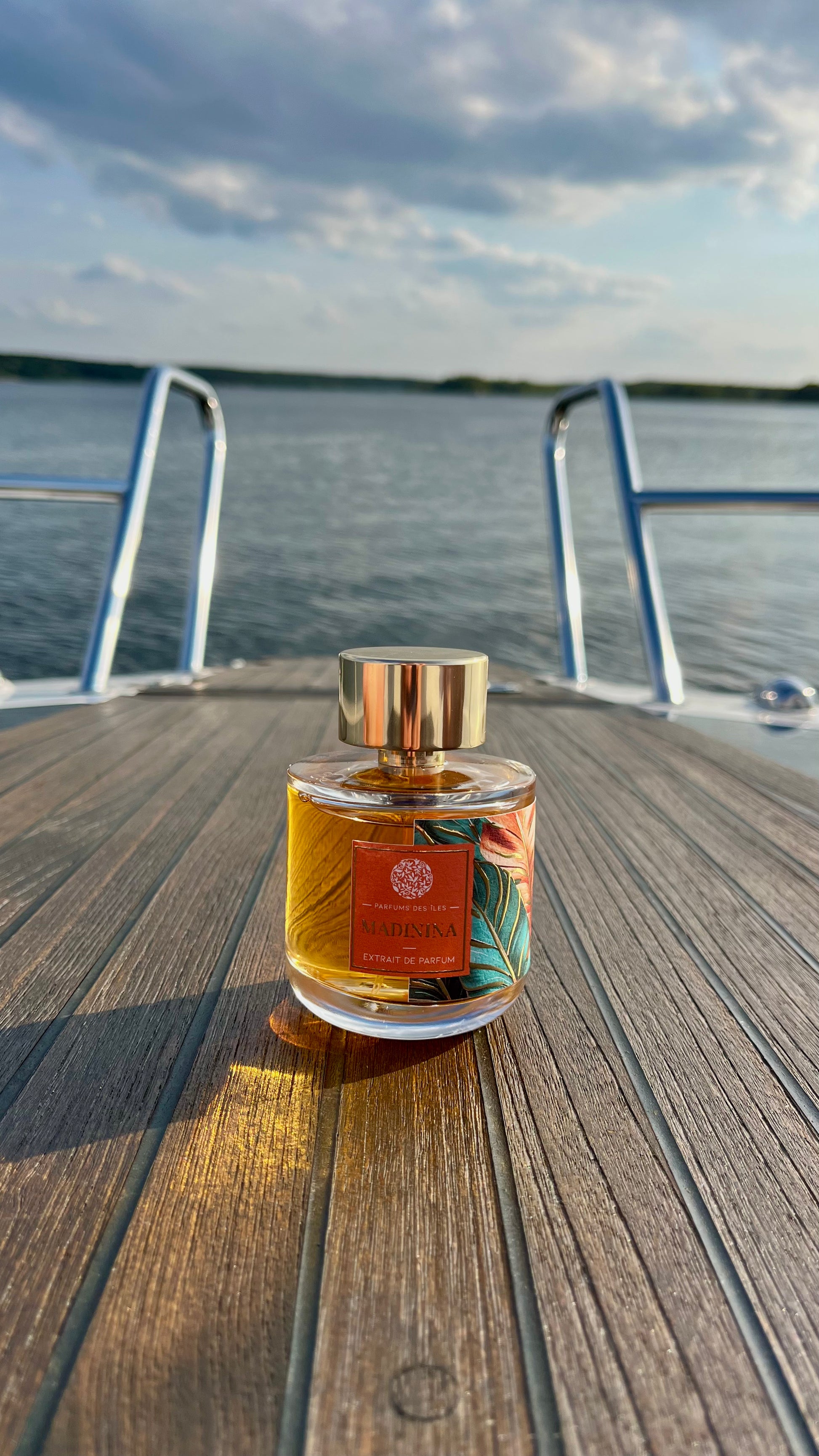Marinina Parfüm 100ml stehend auf dem Boot. Im Hintergrund ein See mit Wolken im Himmel