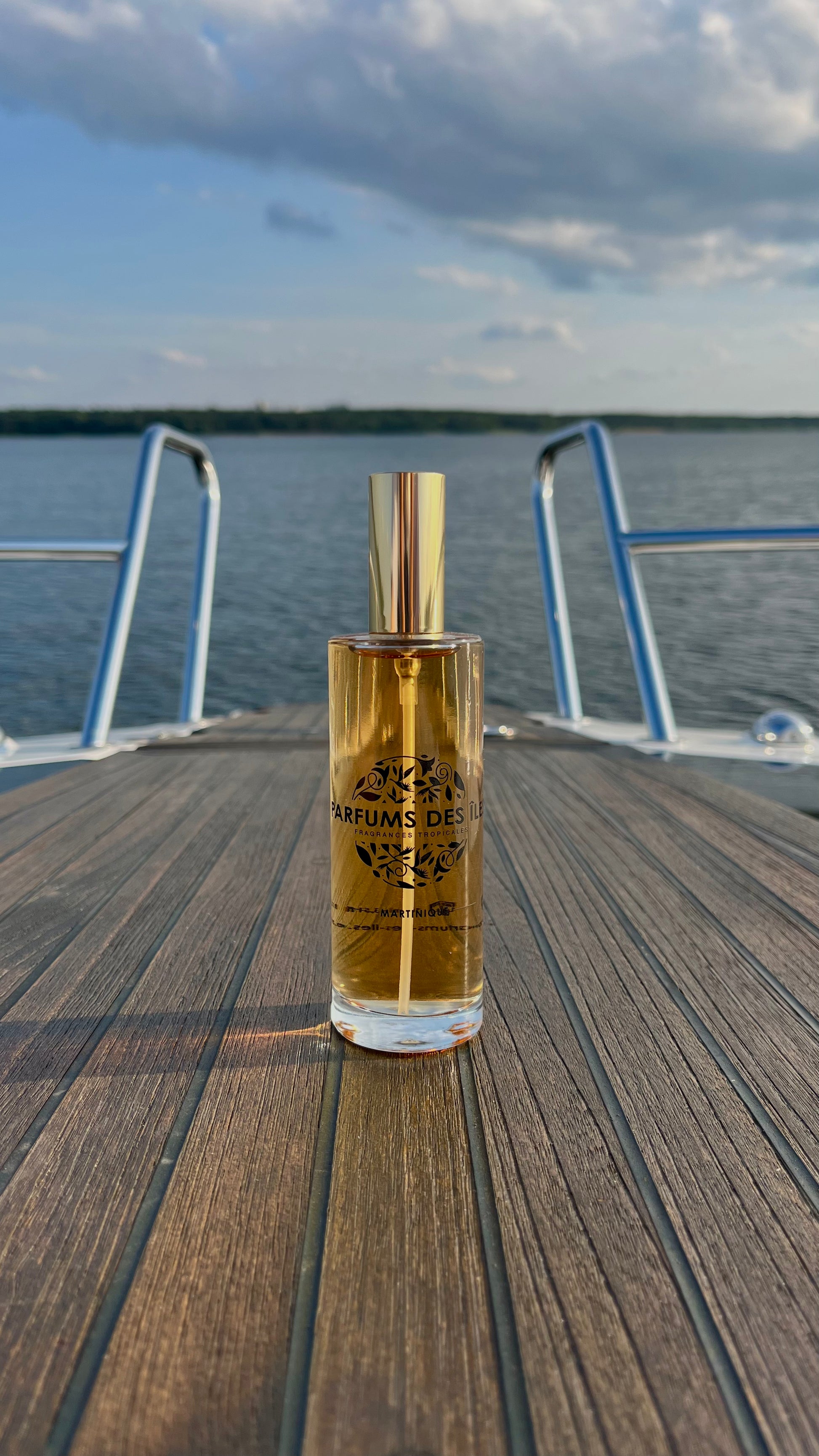 Eau de Parfum Signature Femme 100ml Flacon. Stehend auf einem Boot. Im Hintergrund die Reeling und der See
