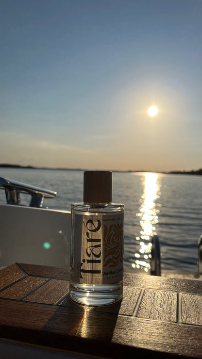Eau de Toilette Tiare 100ml auf einem Boot stehend. Im Hintergrund ein See und Sonnenuntergang