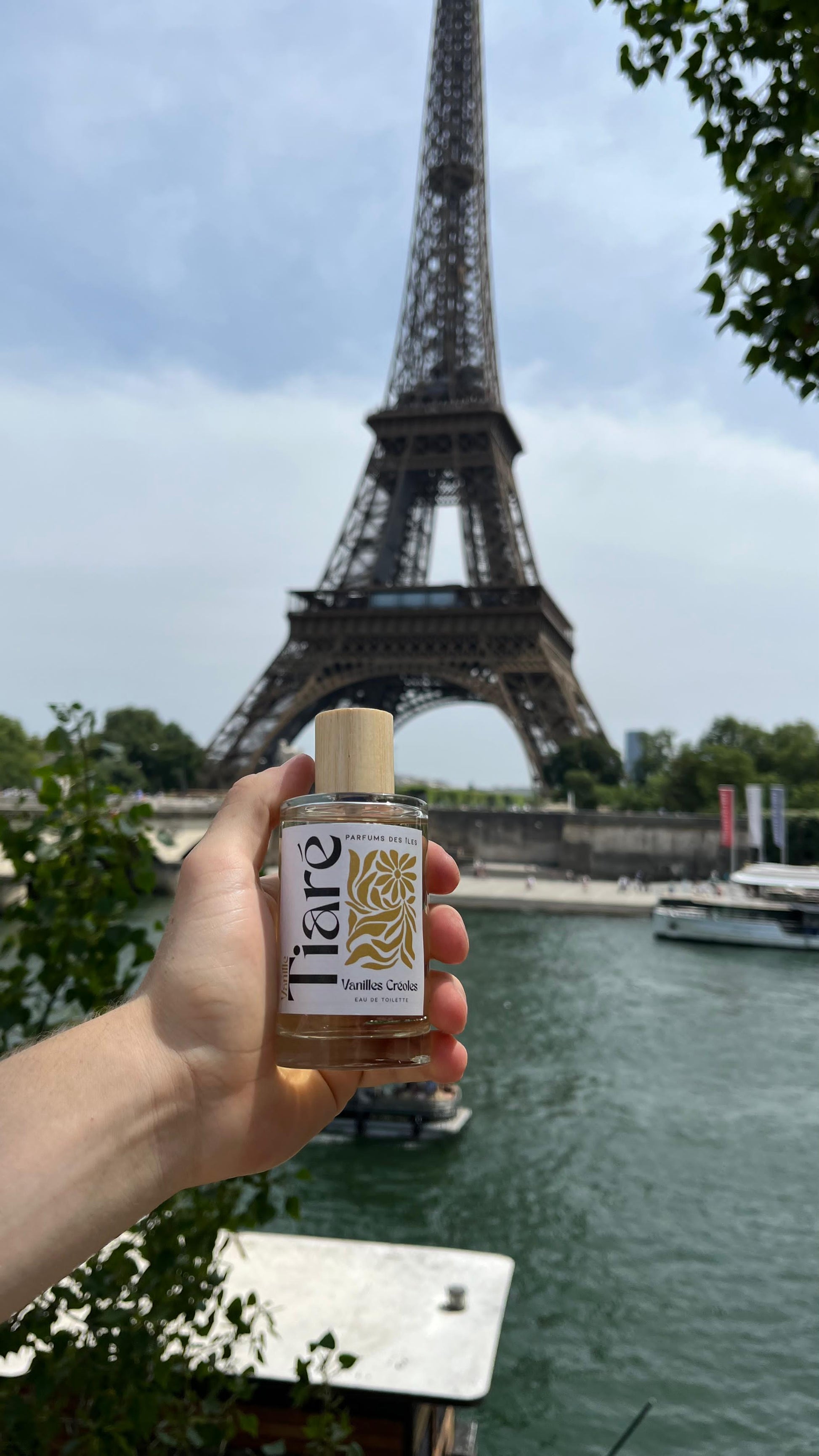 Vanille Creoles Tiare 100ml Glasflacon in der Hand im Hintergrund Eiffelturm